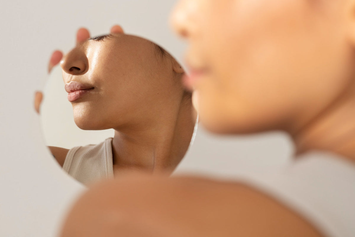 Reflejo de un rostro femenino con piel luminosa como resultado de saber cómo usar PDRN en la piel.