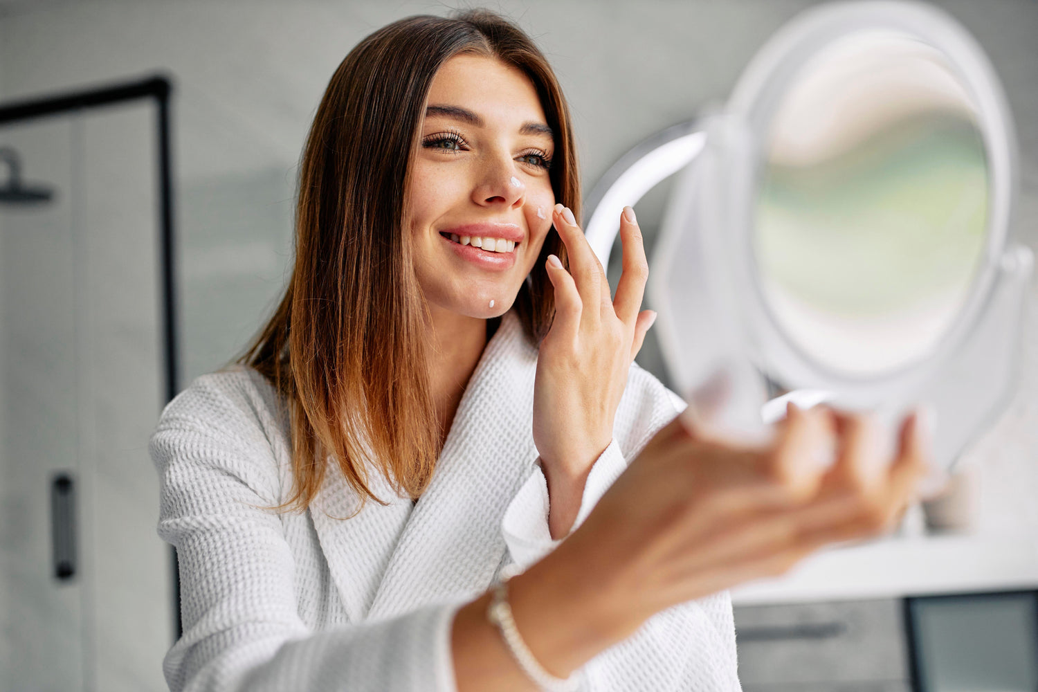 Mujer joven aplicando productos esenciales en su rostro, siguiendo una rutina de skincare minimalista y efectiva.
