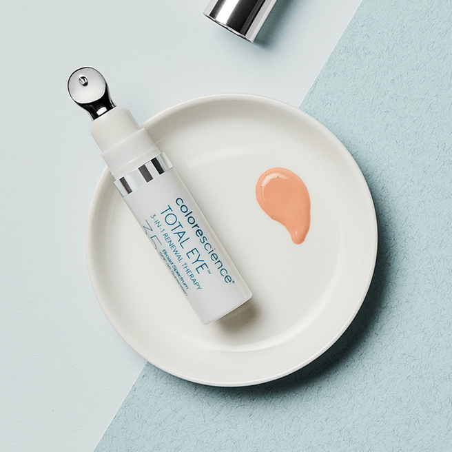 Colorescience Total Eye 3 in 1 Renewal Therapy sobre un plato blanco con muestra del tono fair, sobre un fondo bicolor en tonos azules.
