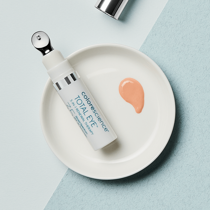 Colorescience Total Eye 3 in 1 Renewal Therapy sobre un plato blanco con muestra del tono fair, sobre un fondo bicolor en tonos azules.