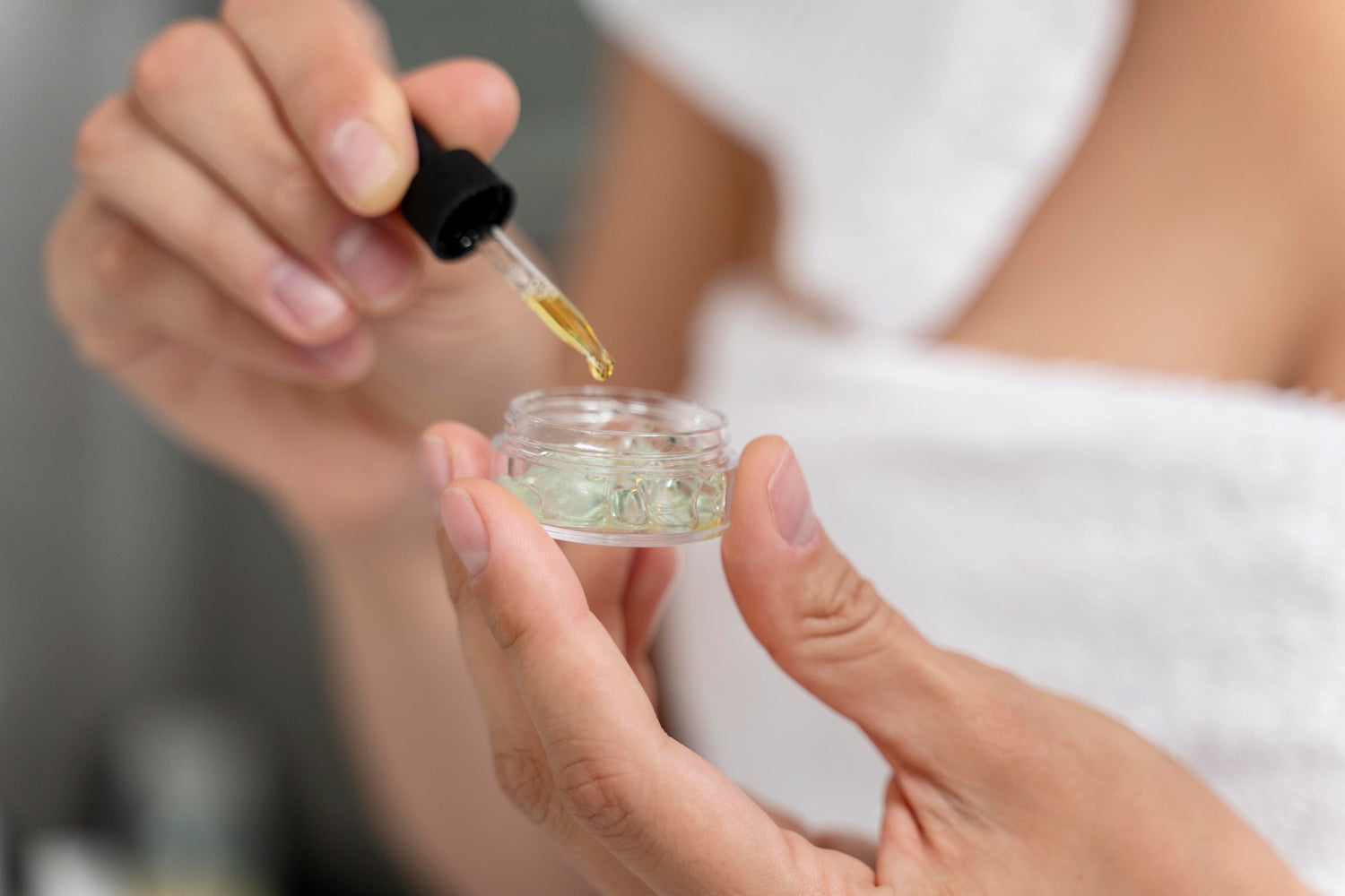 Manos de mujer mezclando un producto de skincare con retinol y otros ingredientes seguros para cuidar la piel correctamente.